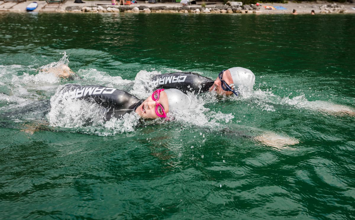 Zwei Sportler schwimmen im Wasser und tragen Blacktec Anzüge von Camaro